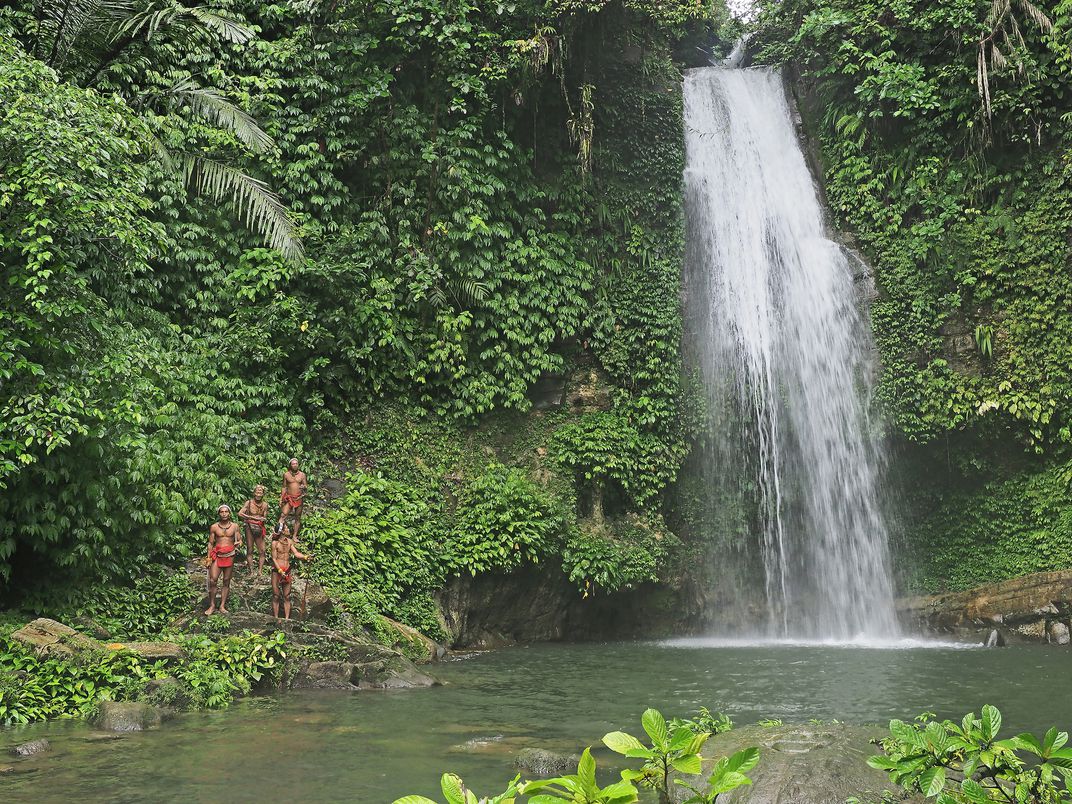 mentawai tribe in kulukubuk waterfall in siberut